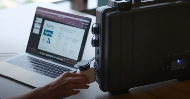 A hand plugs her computer into the ReadyTechGo pack